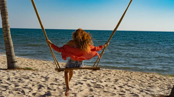 Tatil konsepti. Genç kadın bir plaj salıncak üzerinde salıncak. Phu Quoc plajda mutlu gezgin kadınlar
