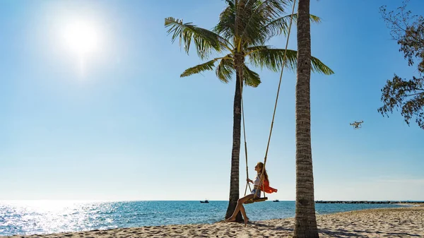 Tatil konsepti. Genç kadın bir plaj salıncak üzerinde salıncak. Phu Quoc plajda mutlu gezgin kadınlar