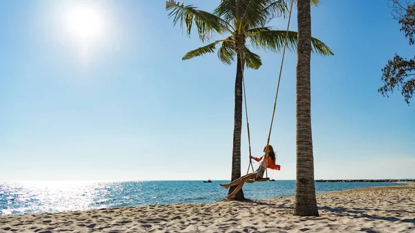 Tatil konsepti. Genç kadın bir plaj salıncak üzerinde salıncak. Phu Quoc plajda mutlu gezgin kadınlar