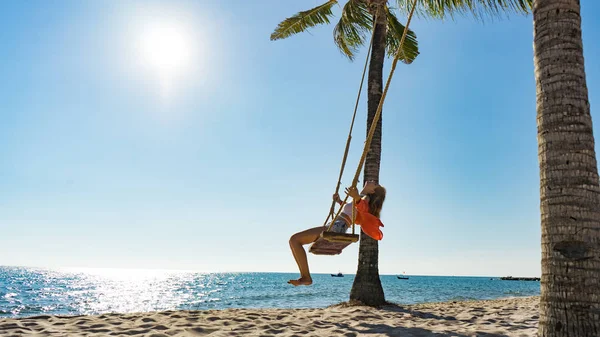 Tatil konsepti. Genç kadın bir plaj salıncak üzerinde salıncak. Phu Quoc plajda mutlu gezgin kadınlar