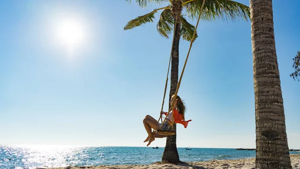 Tatil konsepti. Genç kadın bir plaj salıncak üzerinde salıncak. Phu Quoc plajda mutlu gezgin kadınlar