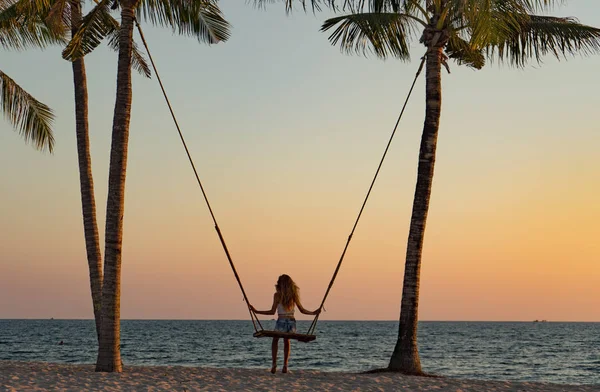 Tatil konsepti. Genç kadın bir plaj salıncak üzerinde salıncak. Phu Quoc plajda mutlu gezgin kadınlar