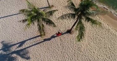 Drone, tropikal kumsalda sallanan genç bayanları ağır çekimde komik duygularla görüntüledi. Vietnam 'da çekildi, 4K çözünürlük videosu. İnsanlar tatillerde seyahat eder.