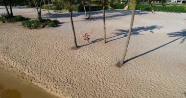 Drone, tropikal kumsalda sallanan genç bayanları ağır çekimde komik duygularla görüntüledi. Vietnam 'da çekildi, 4K çözünürlük videosu. İnsanlar tatillerde seyahat eder.