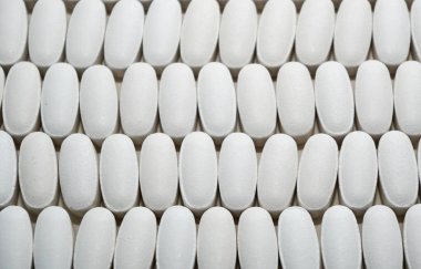 Beyaz oval kalp şeklinde haplar eczane kavramı için bir arka plan olarak birbirlerine closse.