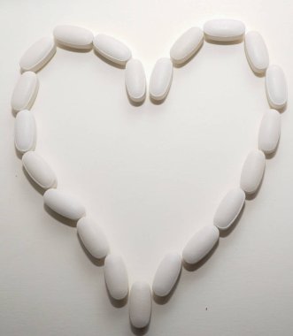 Beyaz oval kalp şeklinde haplar eczane kavramı için bir arka plan olarak birbirlerine closse.