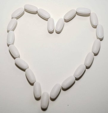 Beyaz oval kalp şeklinde haplar eczane kavramı için bir arka plan olarak birbirlerine closse.