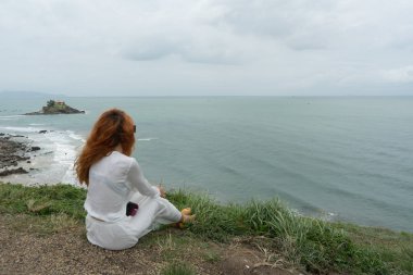  Doğada uzun beyaz etek gezgin kızıl saçlı kız vung Tau.Relax zaman tatil konsepti seyahat güzel görünümü ve küçük bir ada arıyor .
