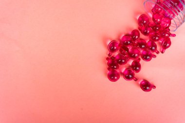 Pembe arka planda pembe vitamin serum kapsülü. Saç dökülmesi tedavisi