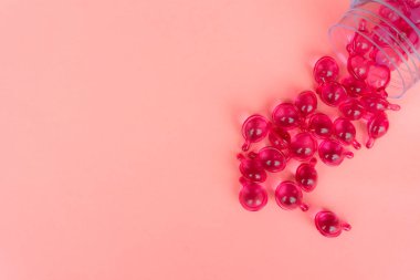 Pembe arka planda pembe vitamin serum kapsülü. Saç dökülmesi tedavisi