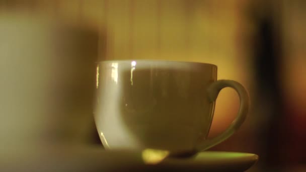 Λευκό φλιτζάνι με το τσάι σε ένα τραπέζι στο Cafe — Αρχείο Βίντεο