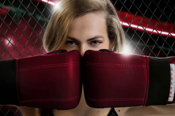 Kameranın kafesin içine bakarak çekici kız mma savaşçı portresi kapatın