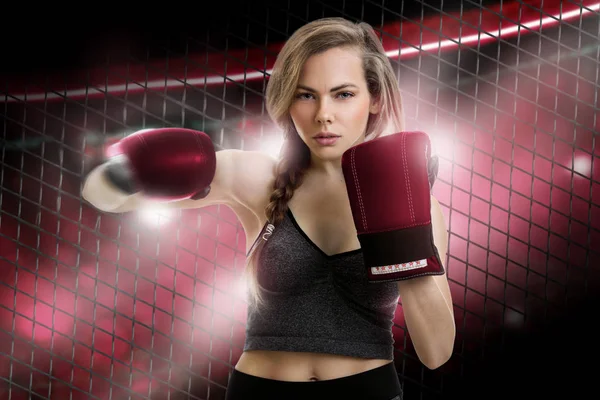 young blonde girl mma fighter in red gloves inside the cage