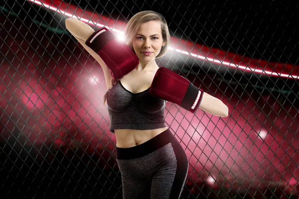 Tatlı genç sarışın kız mma savaşçı kırmızı gülümsüyor kafesin içine fotoğraf makinesinde eldiven