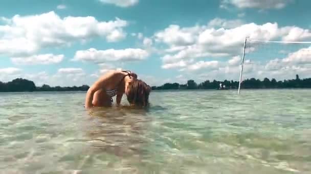 Charming young girl in swimsuit having fun in the sea — Stock Video