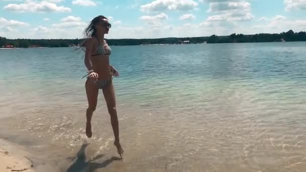 Gelukkig jong meisje in de zee lopen — Stockvideo