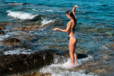 Deniz yaz zaman güzel kalça ile ince genç bayan yüzüyor