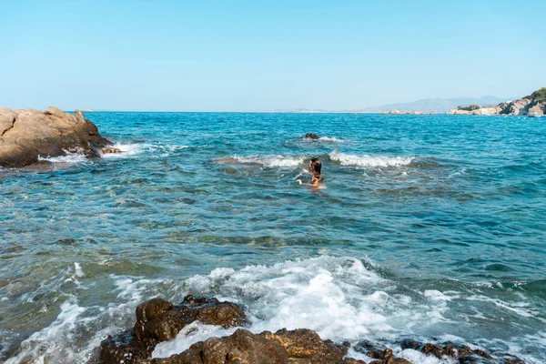 funny young lady swims at the sea summer time