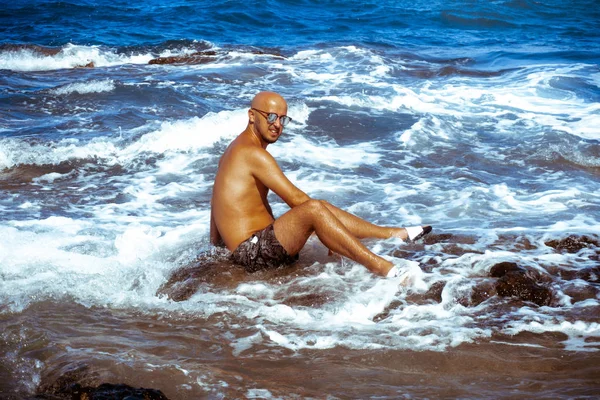 Homme sexy sur la côte rocheuse marine — Photo