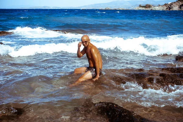 Sexy man on the marine rocky shore — Stock Photo, Image