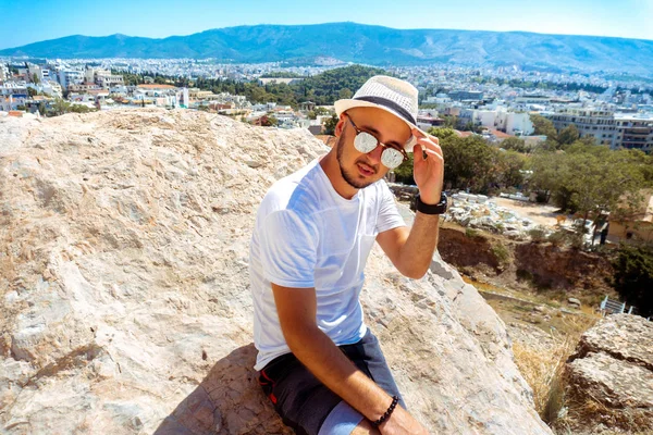 街を見下ろす山の頂上に美しい若いスタイリッシュな男 — ストック写真