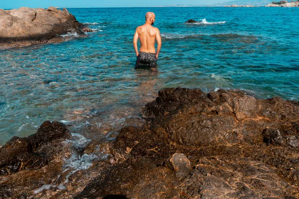 在蓝色岩石海的年轻湿的人 — 图库照片