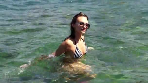 Радостная девушка плавает в море — стоковое видео