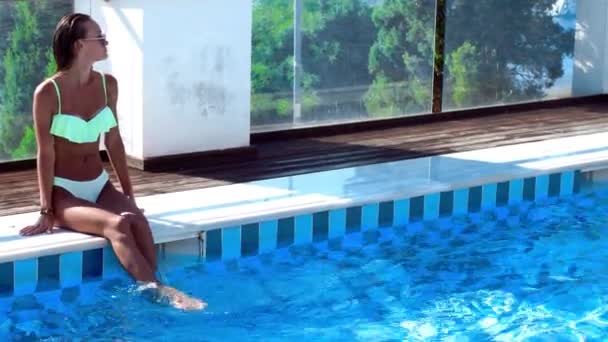 性感的晒黑的女孩坐在游泳池边 — 图库视频影像