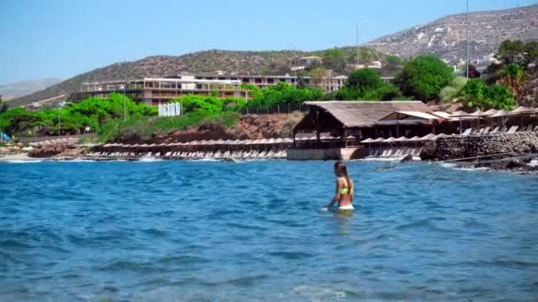 Νεαρό κορίτσι κολυμπάει στην άγρια βραχώδης παραλία — Αρχείο Βίντεο