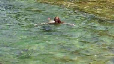 Mutlu kız dalgalı Denizi kayalık bir plajda eğlenmek