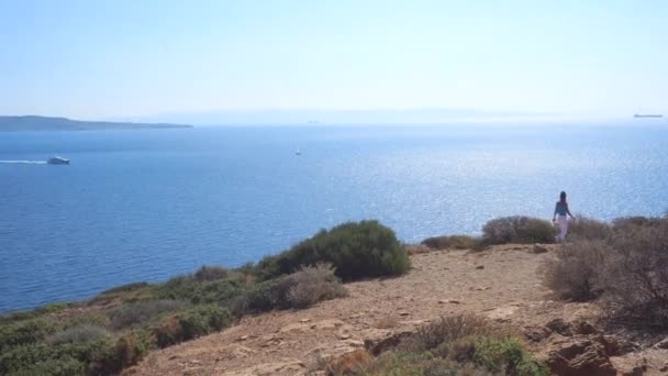 Menina caminha na montanha com vista para o mar — Vídeo de Stock