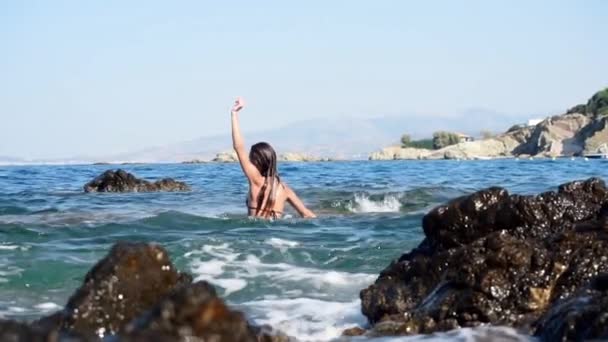 Schöne junge Frau am felsigen Strand — Stockvideo