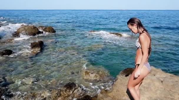 바위 해변에서 아름 다운 젊은 아가씨 — 비디오
