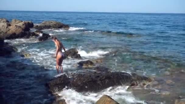 Красива молода леді на кам'янистому пляжі — стокове відео