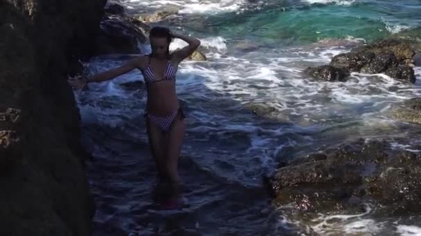 Belle jeune femme à la plage de rochers — Video