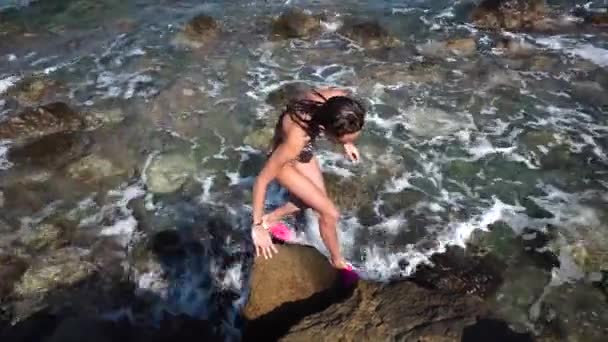 Beautiful young lady at the rocky beach — Stock Video