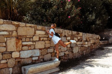 Antik Yunan kalıntıları ile genç kız yürüyor