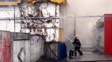 İtfaiyeciler bir yanan bina söndürme