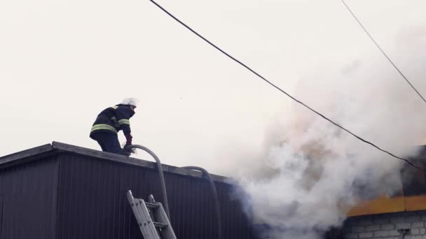 Pemadam kebakaran memadamkan sebuah bangunan yang terbakar — Stok Video