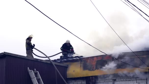 Пожежники гасять палаючу будівлю — стокове відео