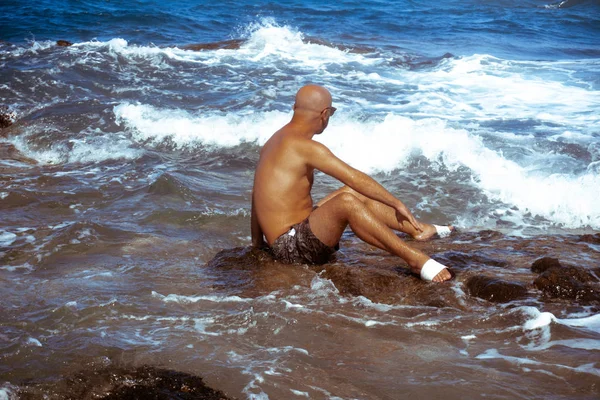 Bel homme sur le rivage rocheux marin — Photo