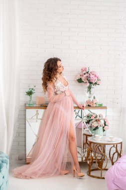 evde pembe elbiseli güzel hamile bayan