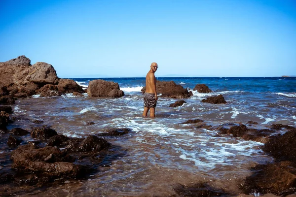 Stilig man på den marina rocky shore — Stockfoto