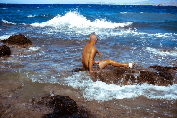 Bel homme sur le rivage rocheux marin — Photo
