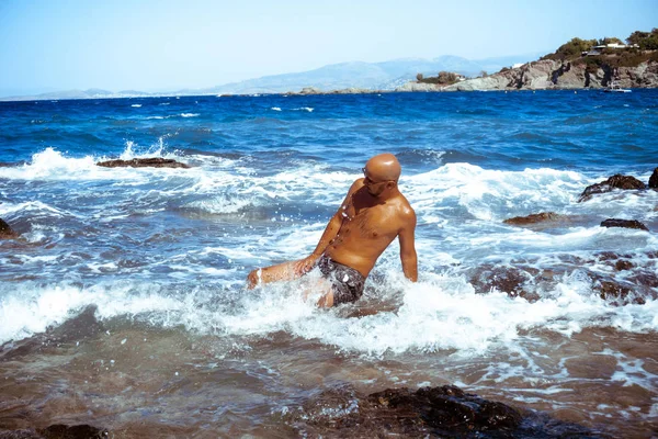 Handsome man on the marine rocky shore — Stock Photo, Image