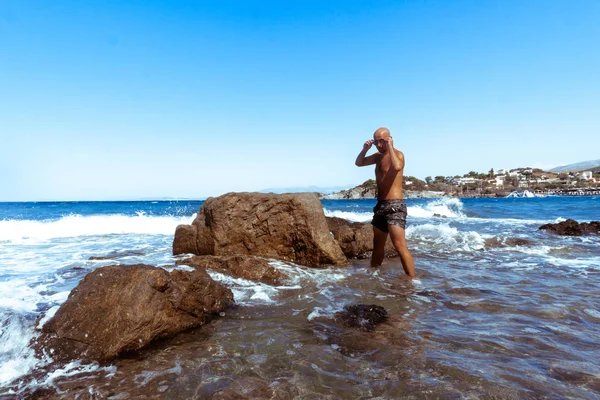 Schöner Mann an der marinen felsigen Küste — Stockfoto