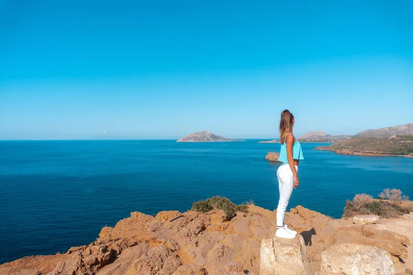 Flicka på en hög klippa över havet — Stockfoto