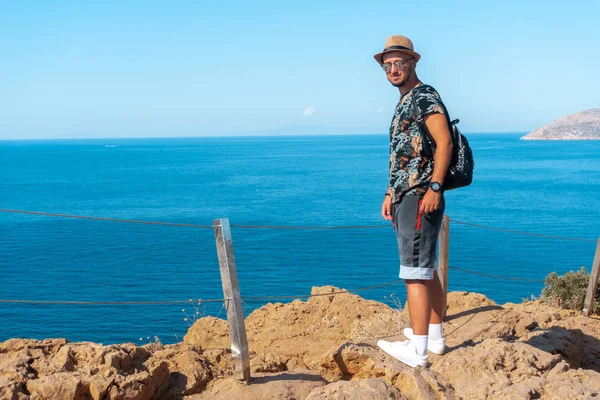 Élégant jeune gars sur la falaise par la mer — Photo