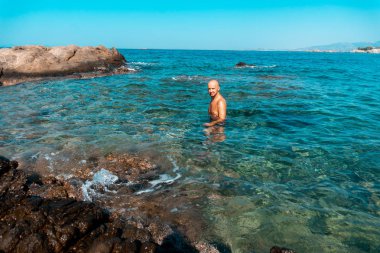 kayalık deniz kıyısında yakışıklı adam