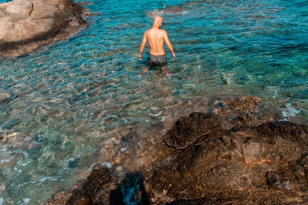 Schöner Mann an der marinen felsigen Küste — Stockfoto